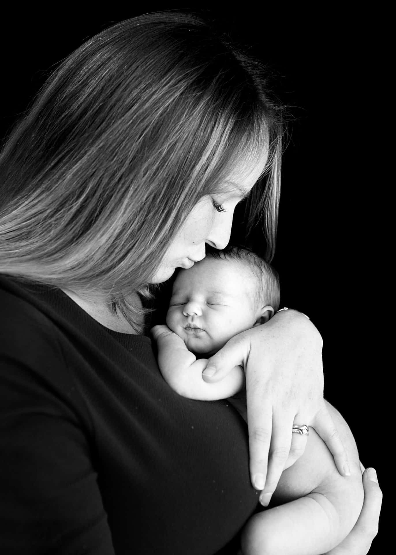 A Woman Is Holding Her Newborn Baby In Black And White