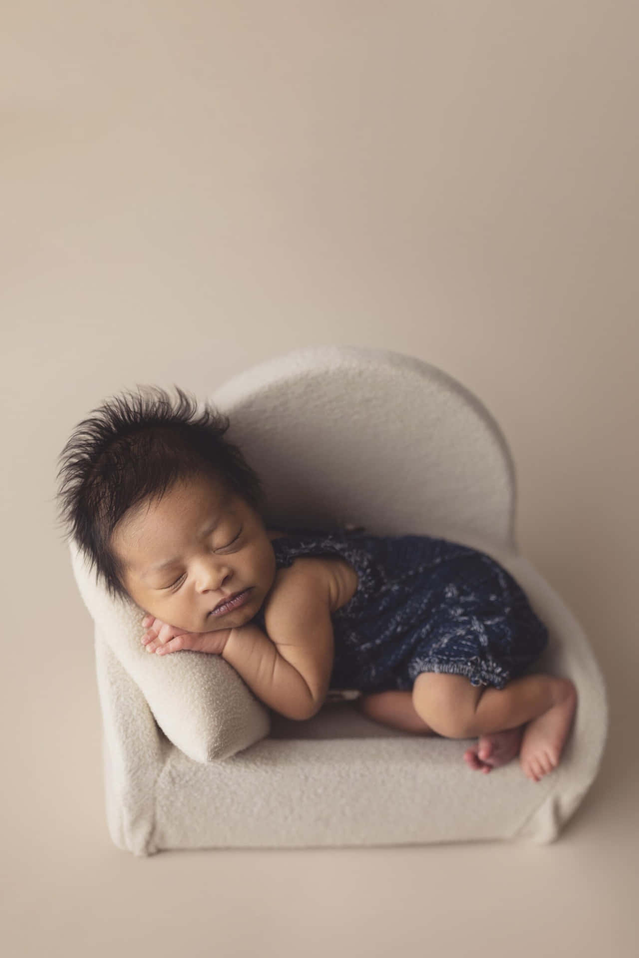 A Baby Sleeping In A White Chair
