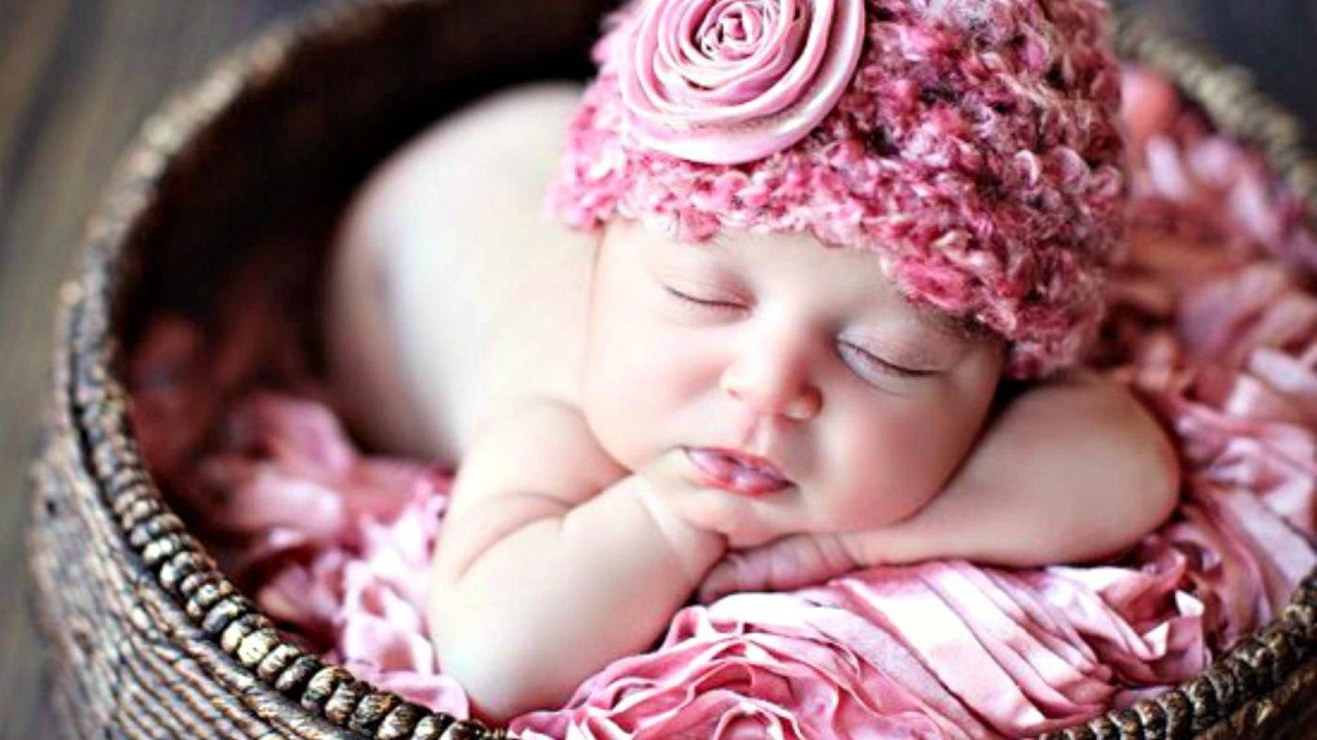 Neugeborenesbaby In Rosa Mit Blumen Wallpaper