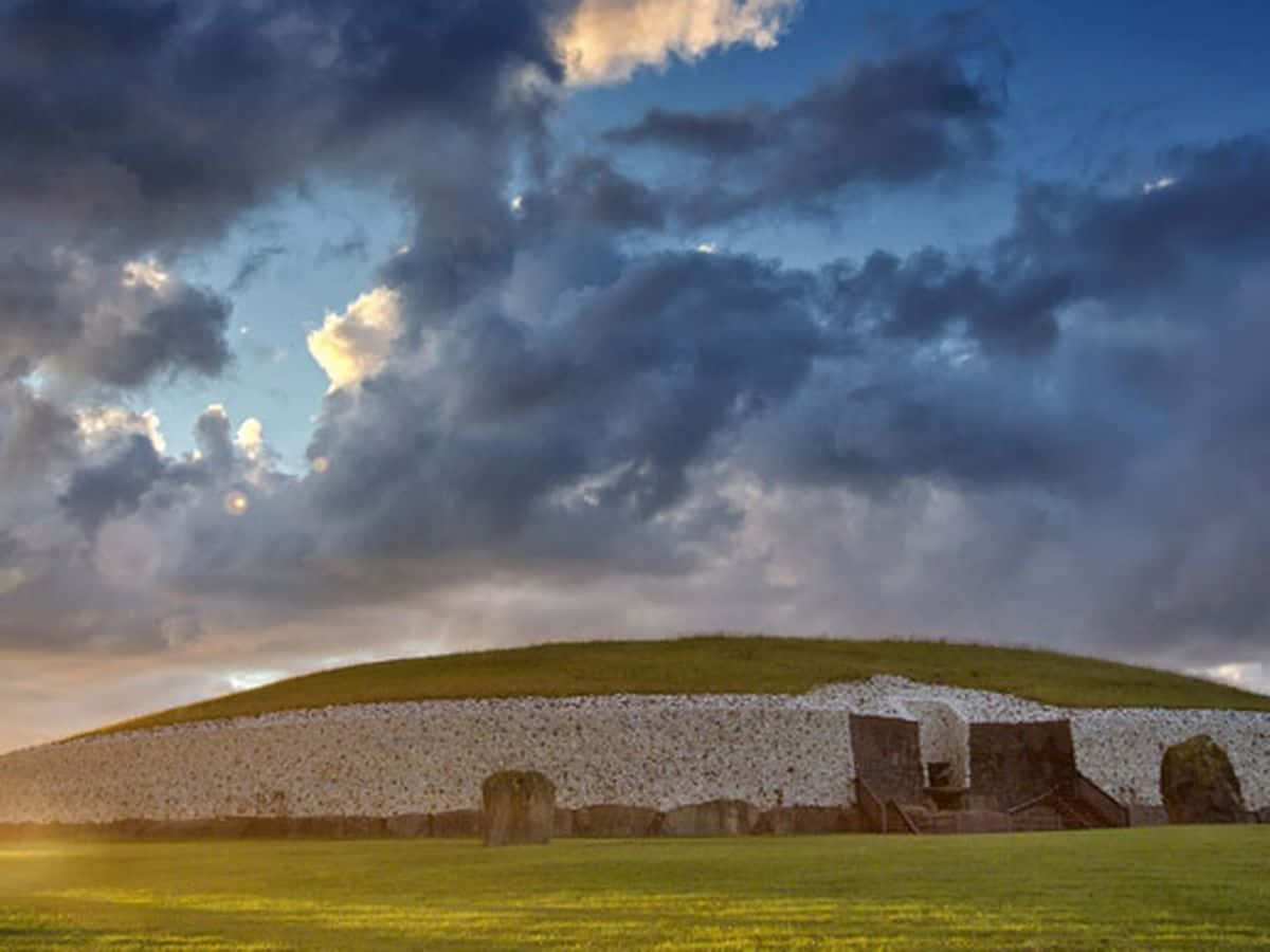 Newgrange With Stormy Clouds And Sunset Lighting Wallpaper