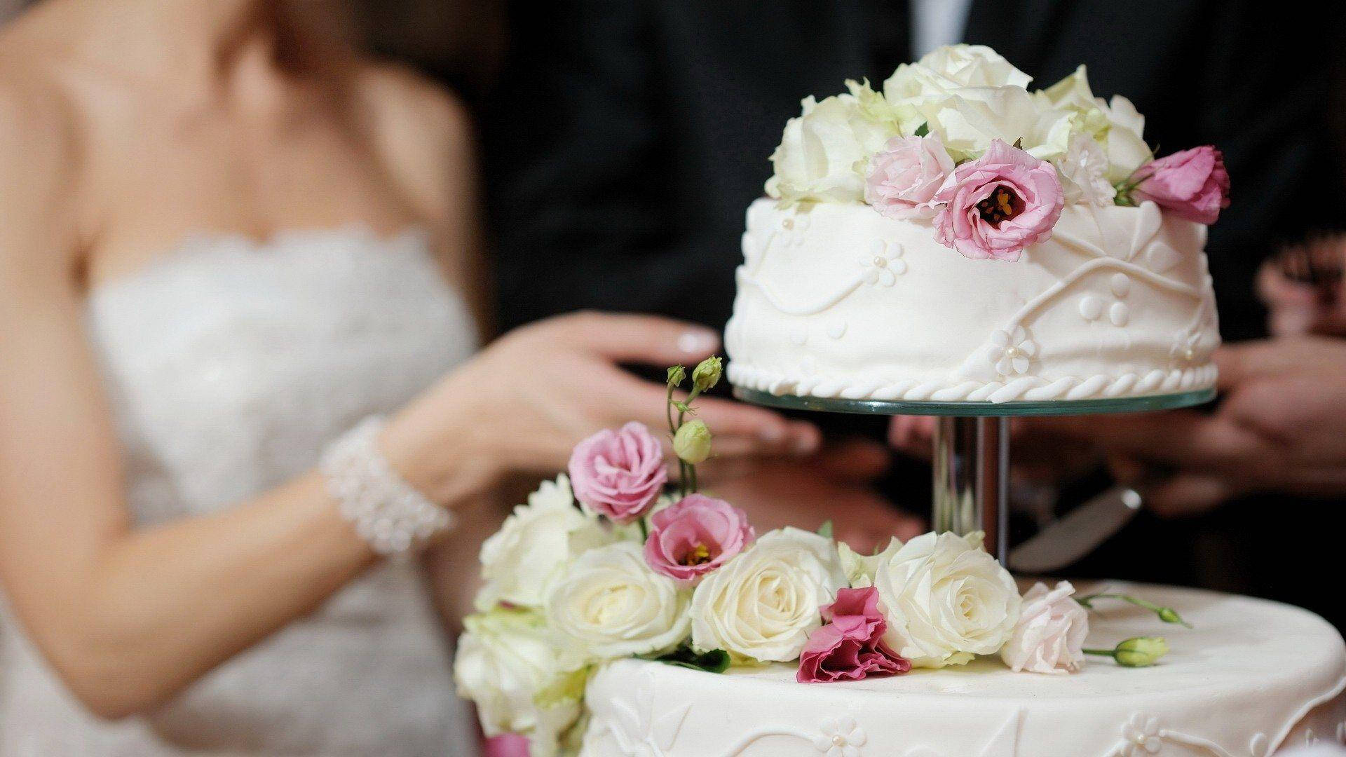 Newlyweds Slicing Floral Wedding Cake Wallpaper