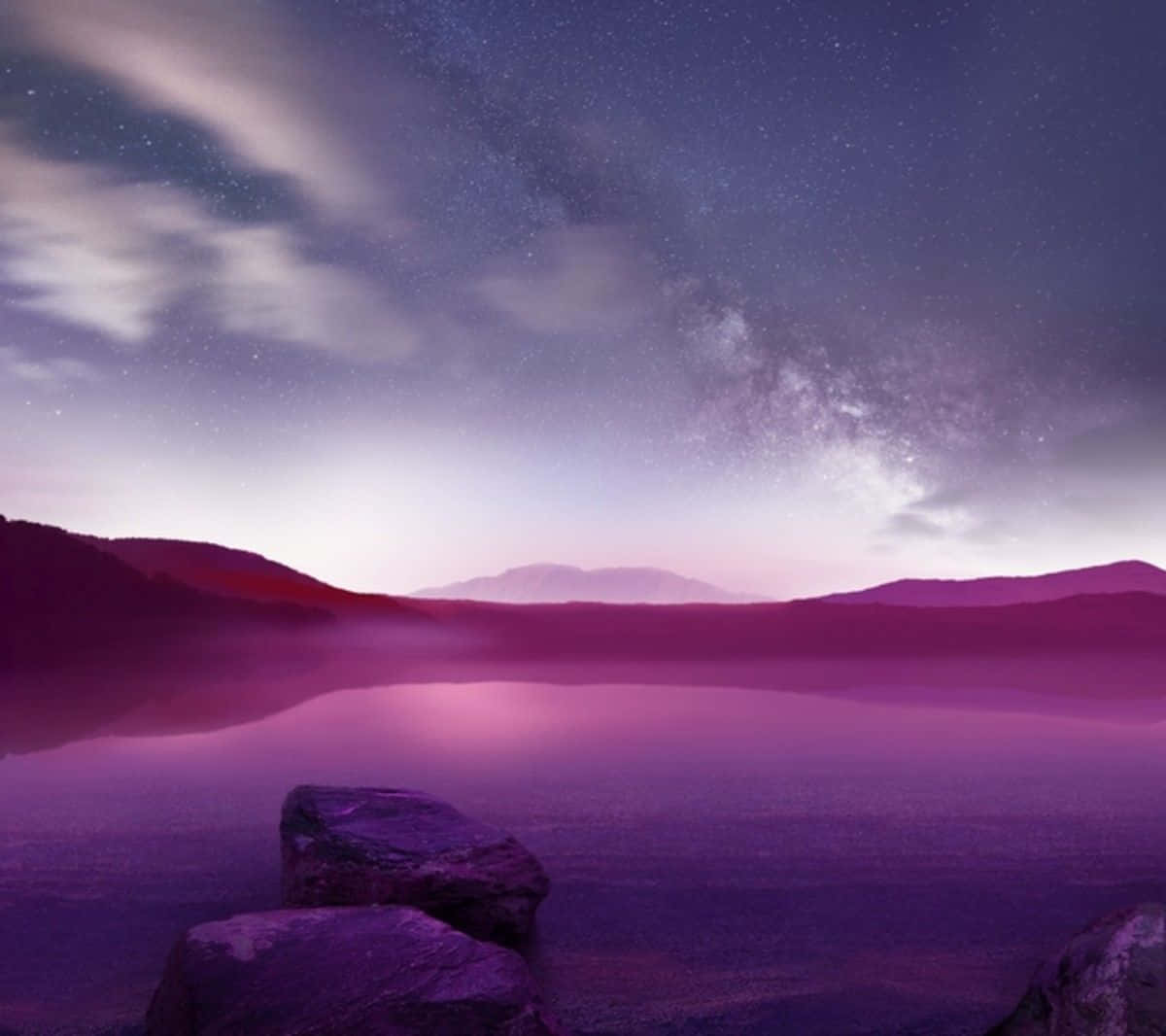 A Purple Sky With Rocks And A Lake Wallpaper
