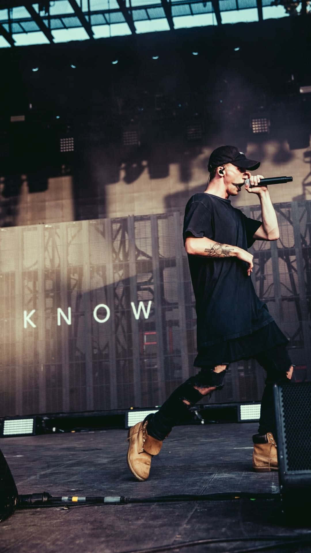 A Man On Stage With The Words Know Wallpaper