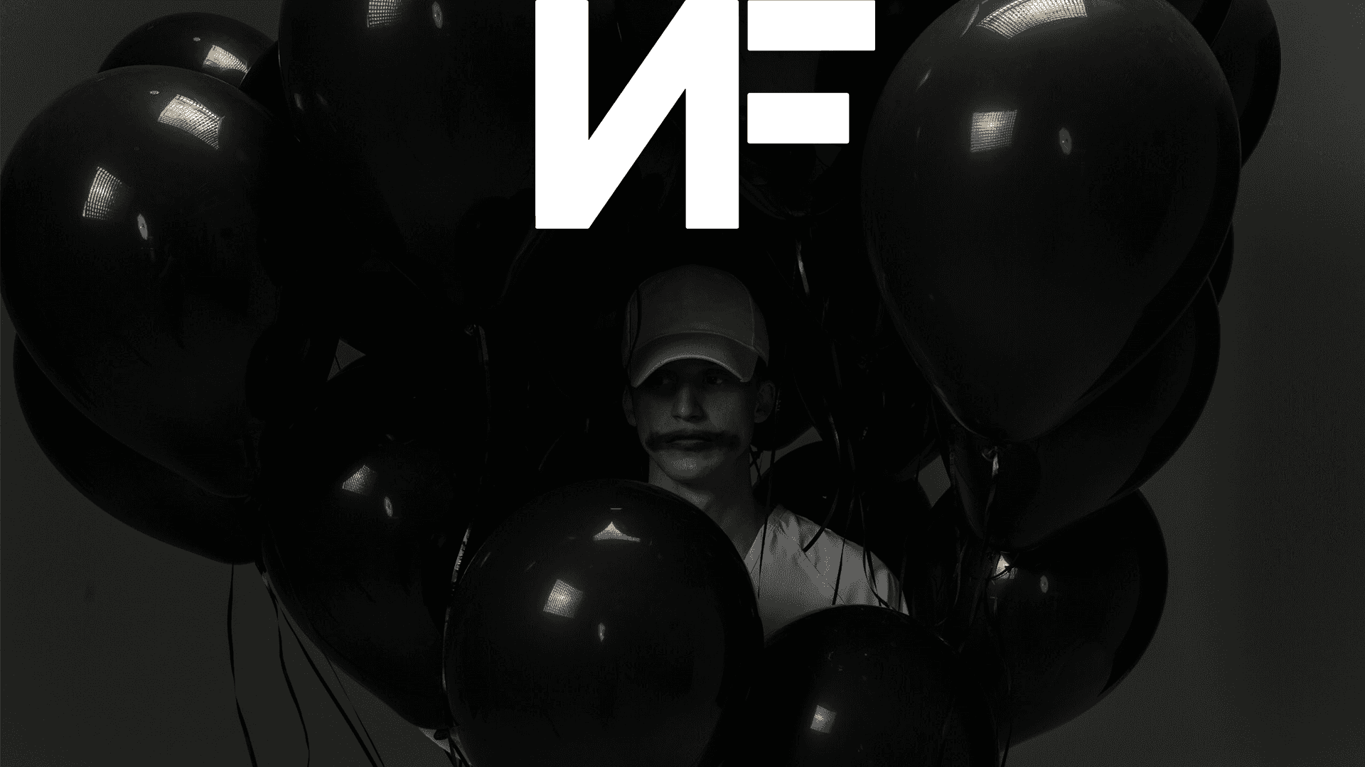 Get your very own Non-Fungible Tokens (NFTs) and join the thriving digital asset revolution! Background — A person with a mustache and cap peeks through a cluster of glossy black balloons under dramatic studio lighting.