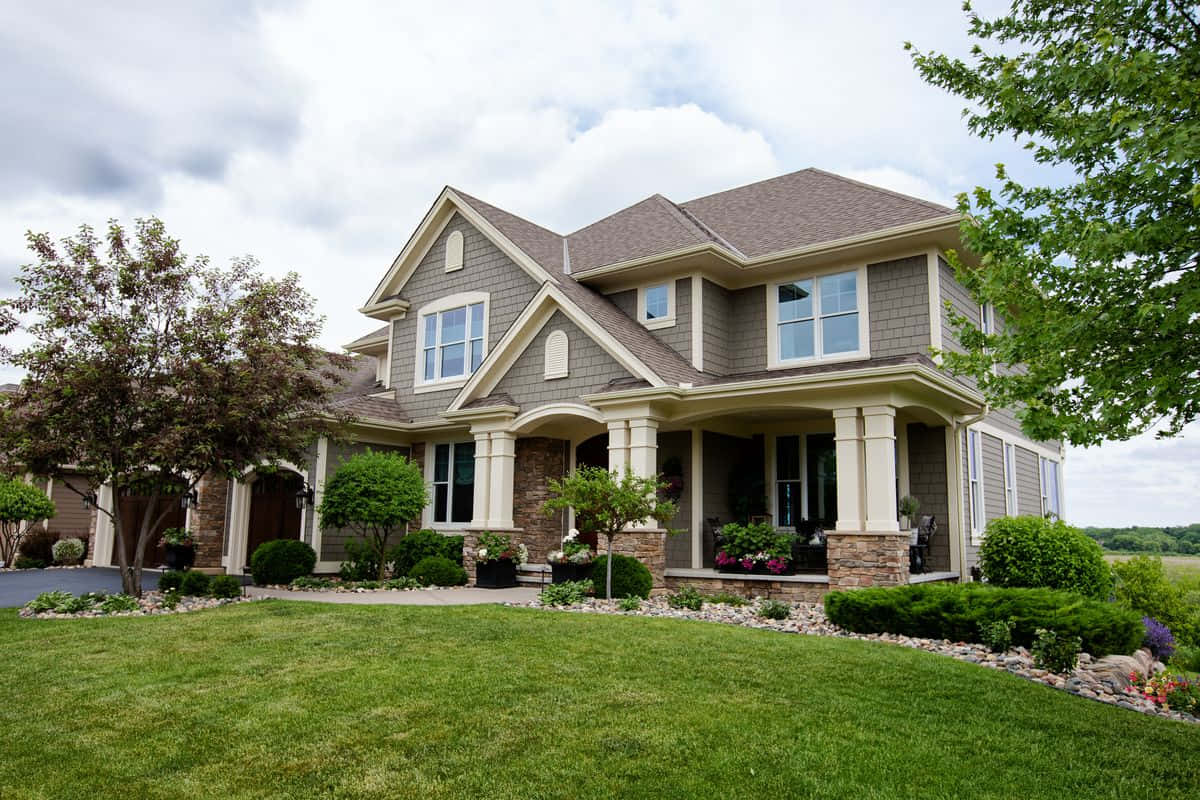 A Home With A Large Front Yard And Landscaping
