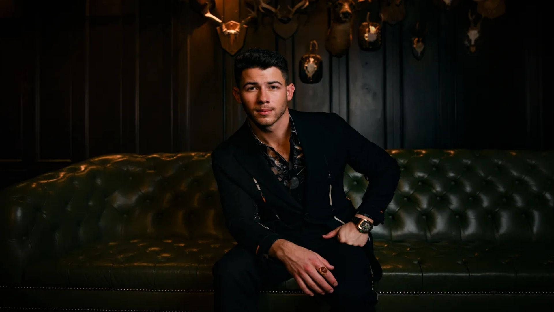Nick Jonas på elegant sofa iført rød Wallpaper