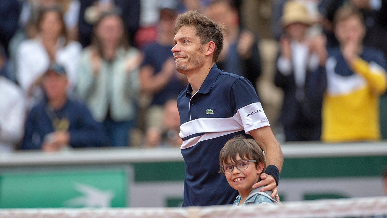 Tennis legend, Nicolas Mahut, celebrates victory with his son on court Wallpaper
