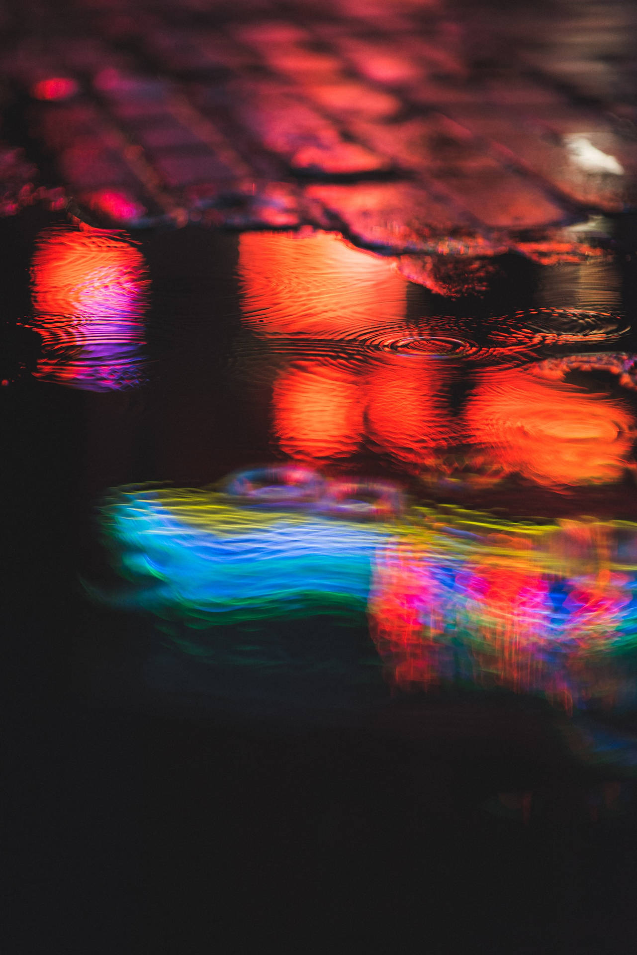 Vibrant Night Colors Reflecting on an Urban Puddle Wallpaper