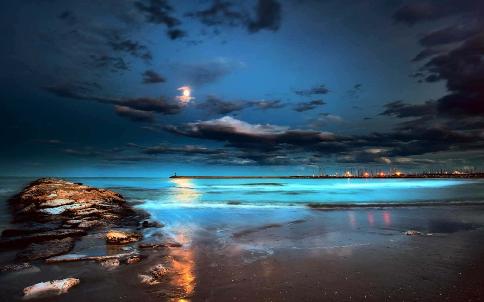 Immaginenotturna Di Una Spiaggia Luminosa Blu