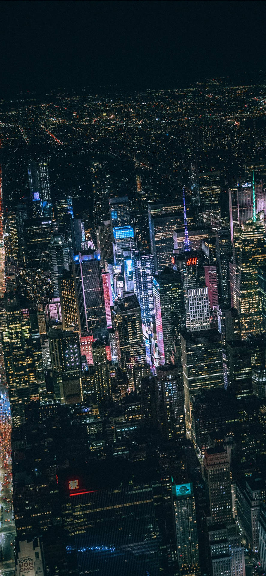 Skyscrapers light up the night sky in Night City. Wallpaper