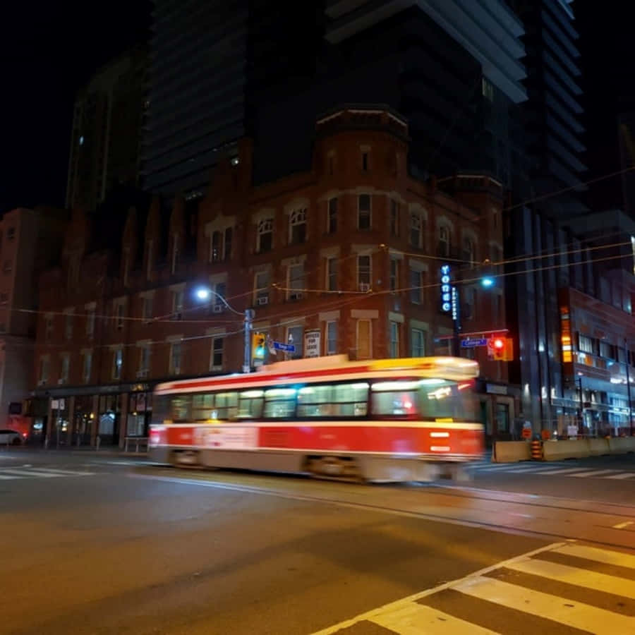 Nighttime Cityscapewith Moving Streetcar Wallpaper
