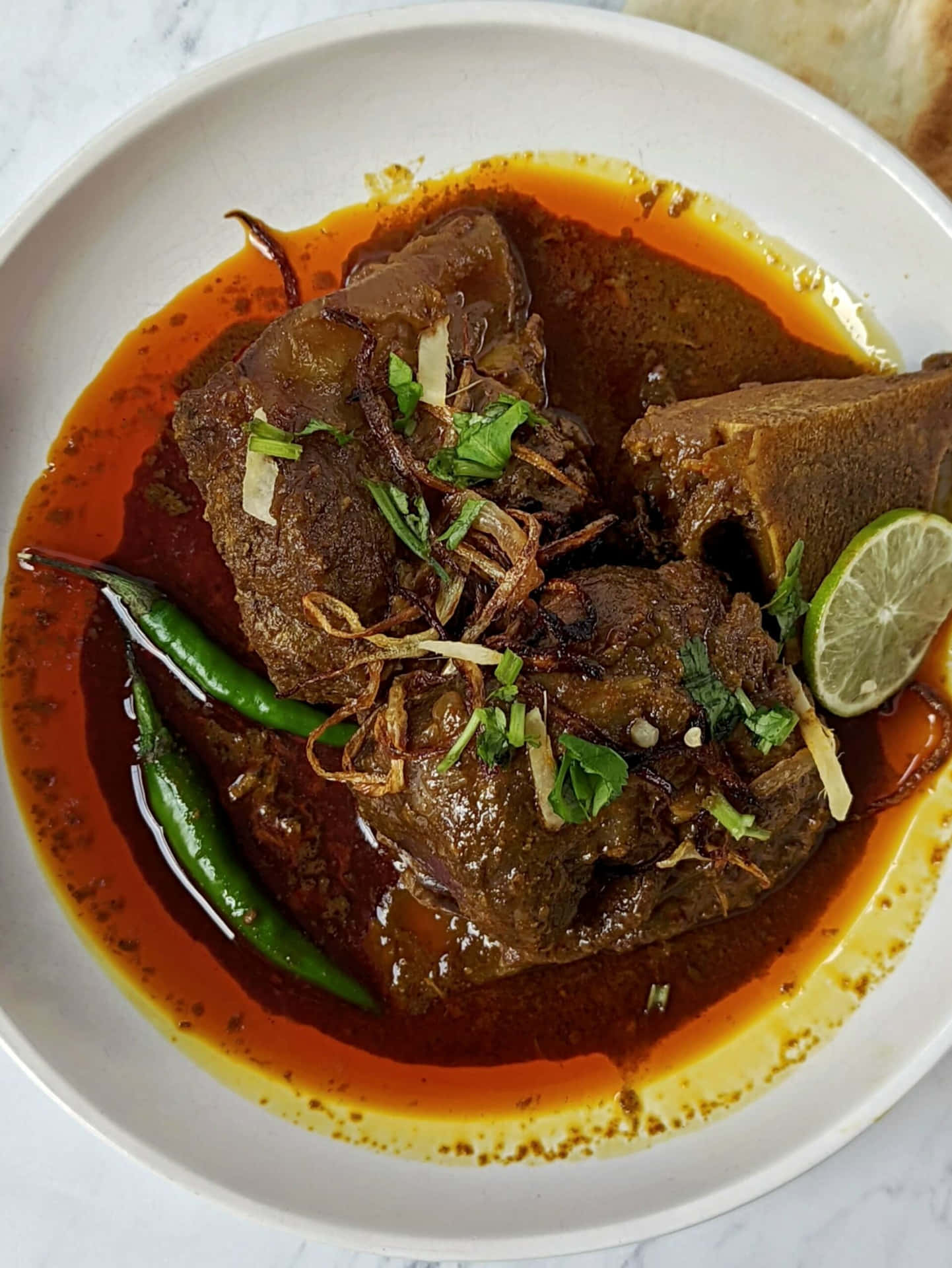 Delicious Nihari served with garnishing on a wooden table Wallpaper