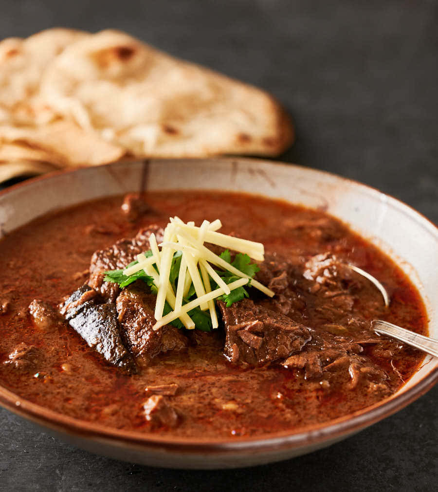 Caption: Delightful Bowl of Nihari - A Feast for the Eyes and Palate Wallpaper