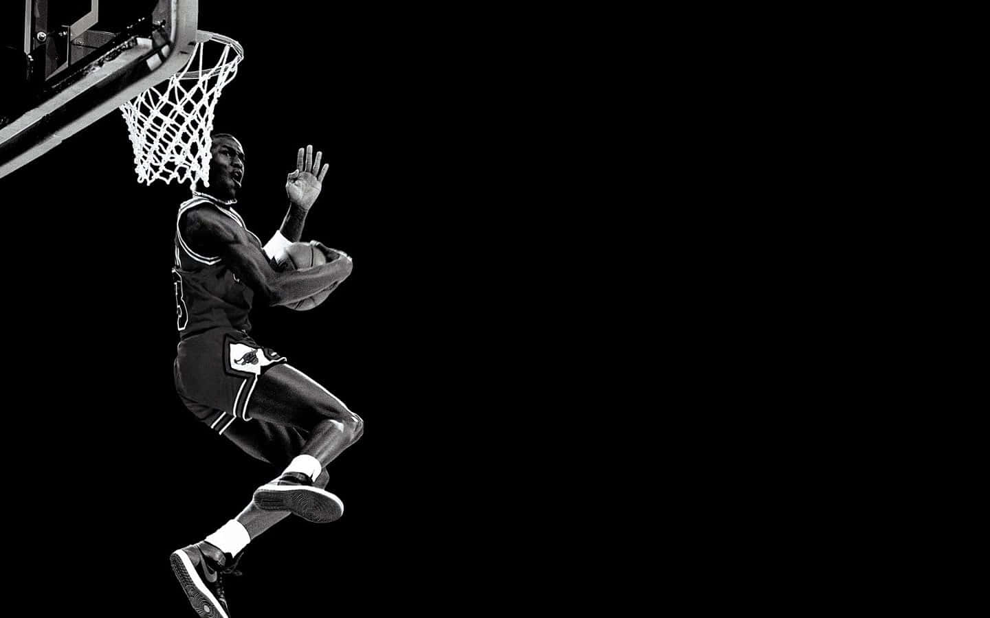A Basketball Player Is Dunking The Ball In Black And White Wallpaper