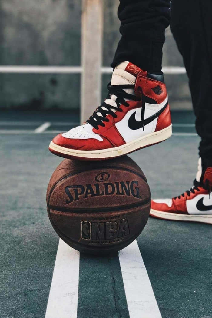 Eineperson Steht Auf Einem Basketballplatz Mit Einem Paar Air Jordans. Wallpaper