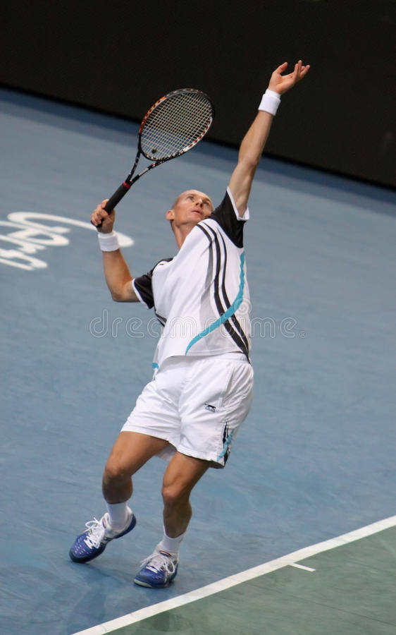Nikolay Davydenko delivering a powerful jumping serve in tennis match. Wallpaper