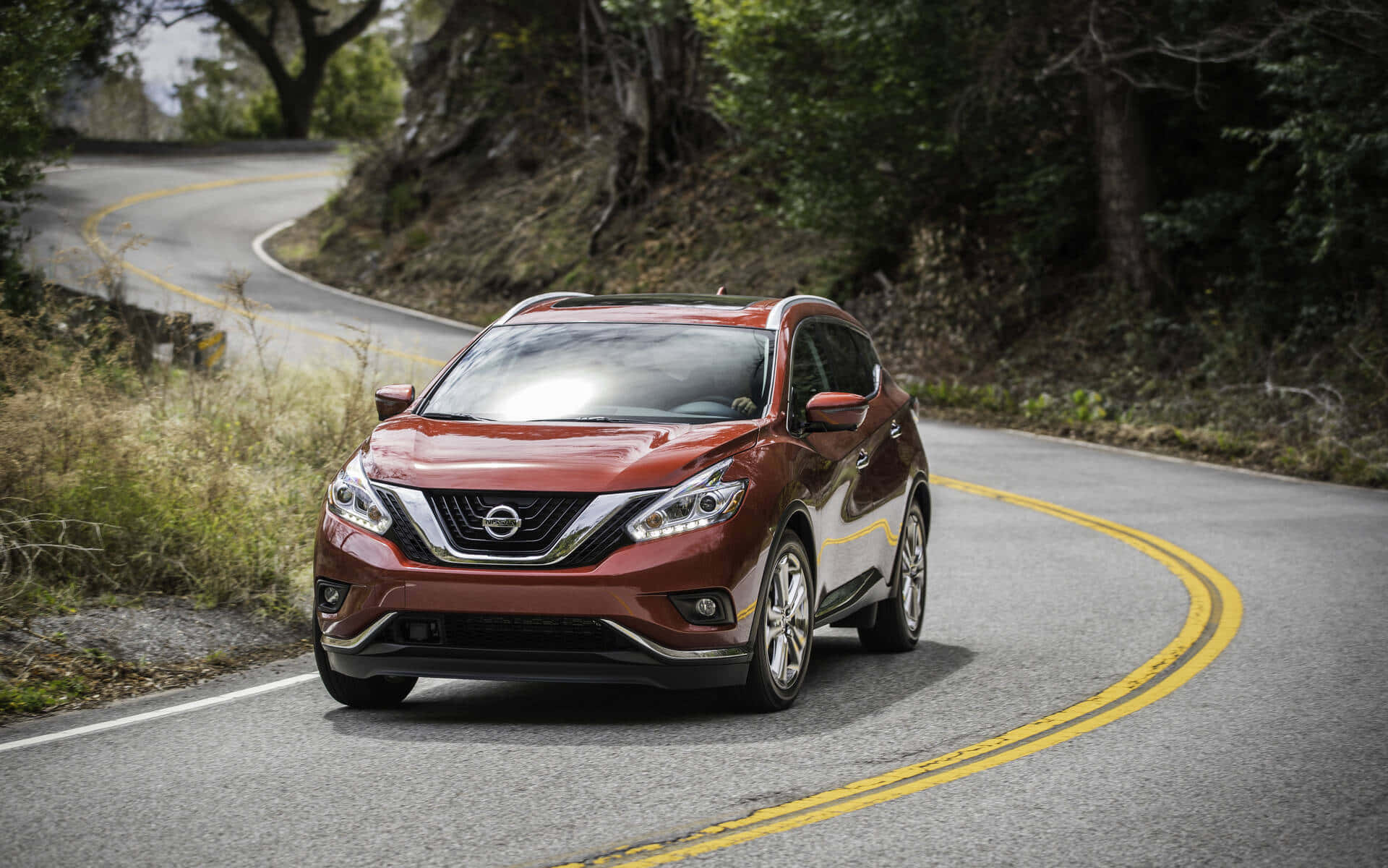 Sleek Nissan Murano Driving On A Picturesque Road Wallpaper