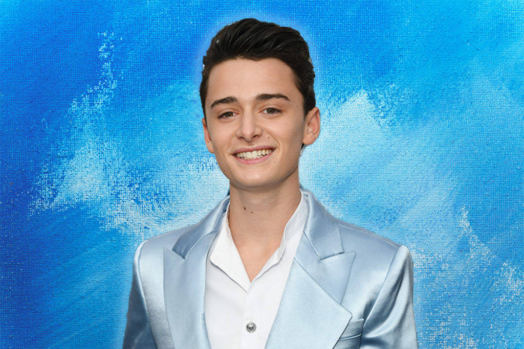 Noah Schnapp Smiling Against Blue Abstract Background Wallpaper