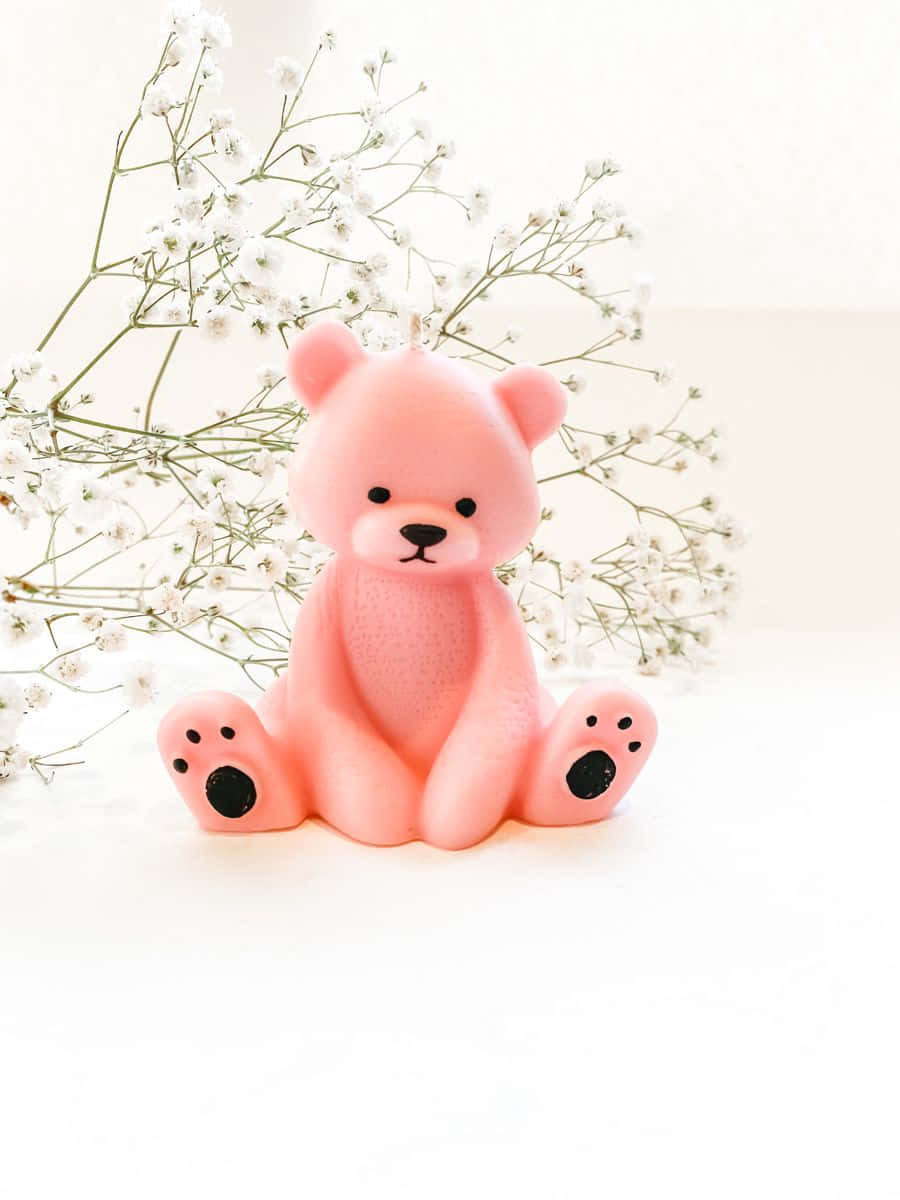 A Pink Teddy Bear Sitting On A White Surface
