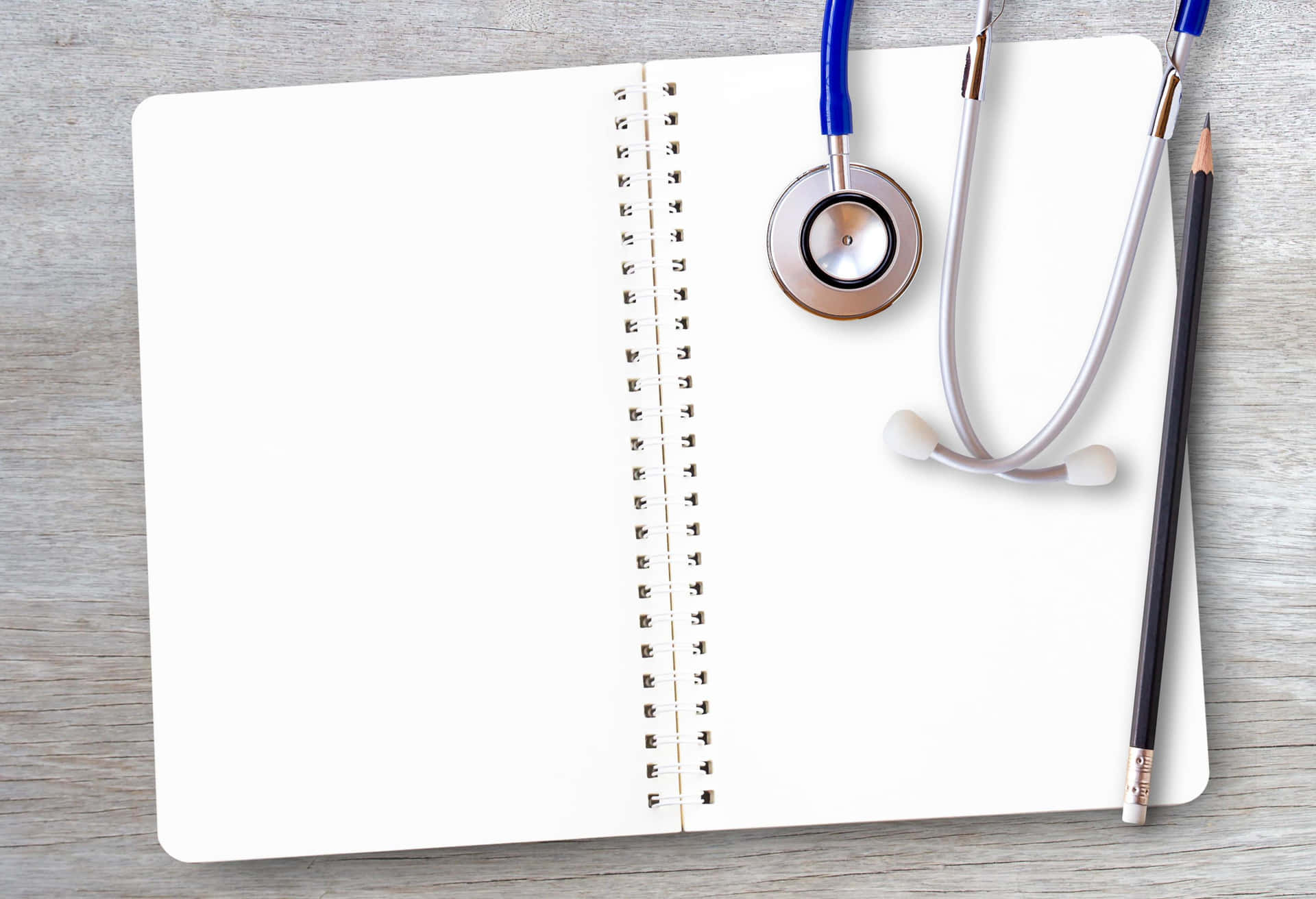 A Blank Notebook With A Stethoscope And Pen On A Wooden Table
