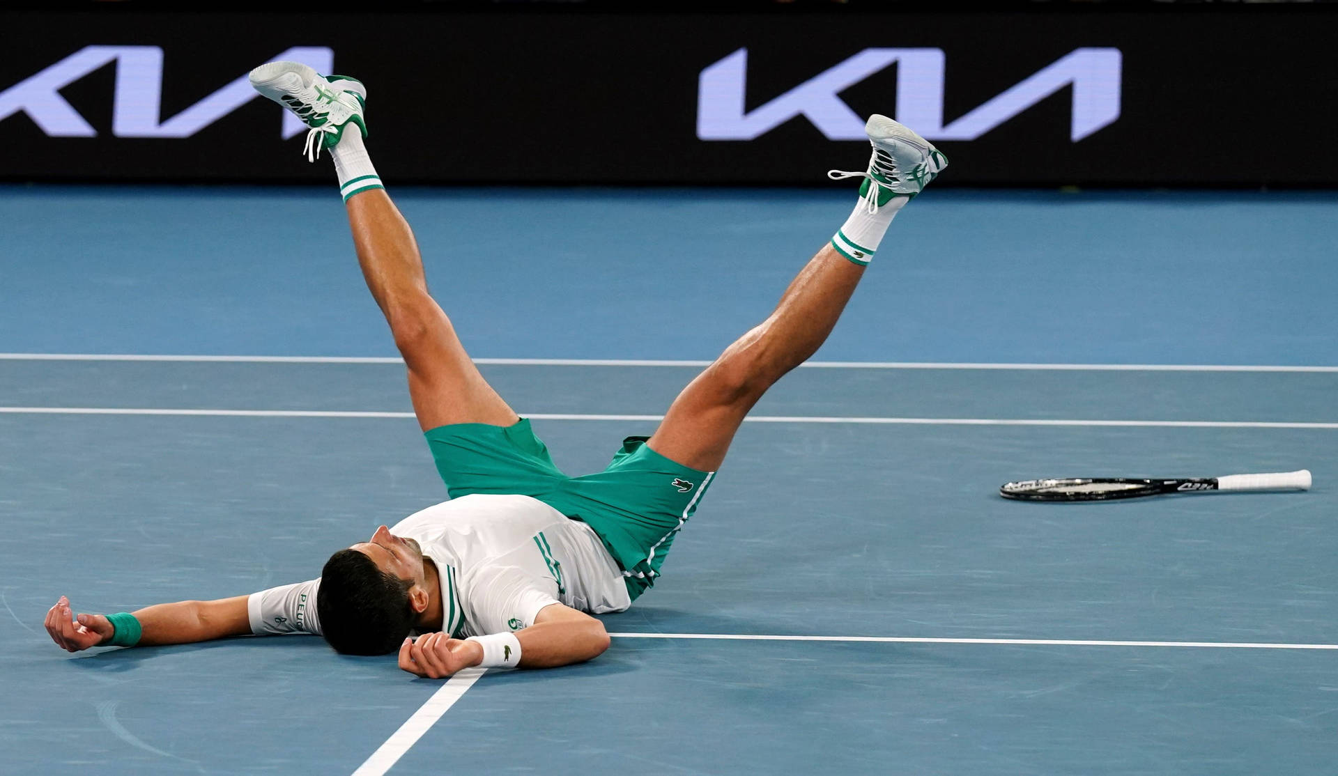Novak Laying On Australian Open Court Background