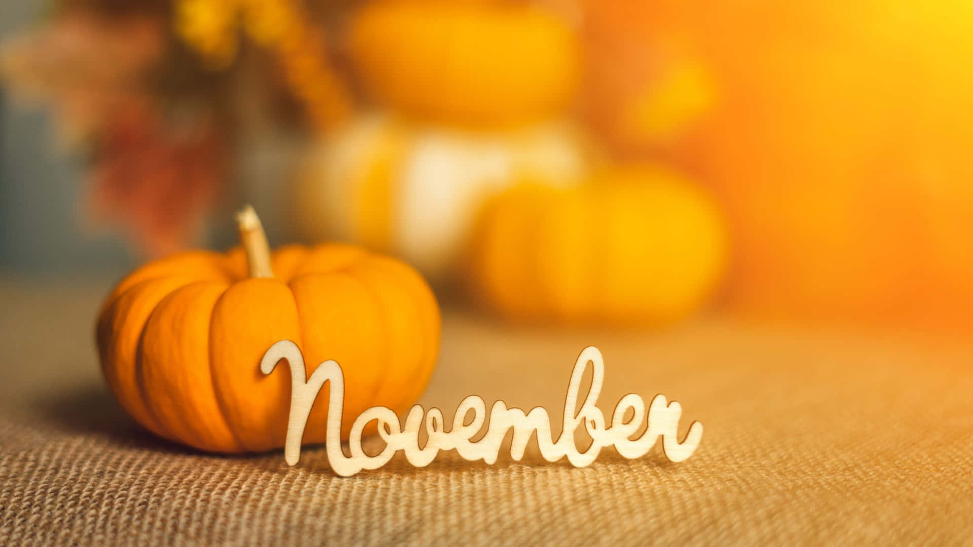 November Pumpkins On A Table With A Candle Wallpaper