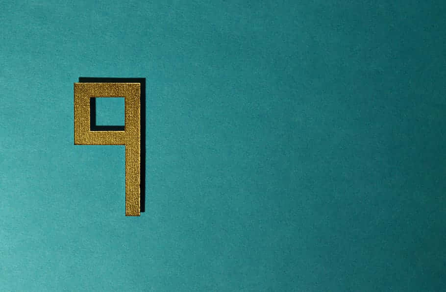 A Gold Letter P On A Turquoise Background Wallpaper