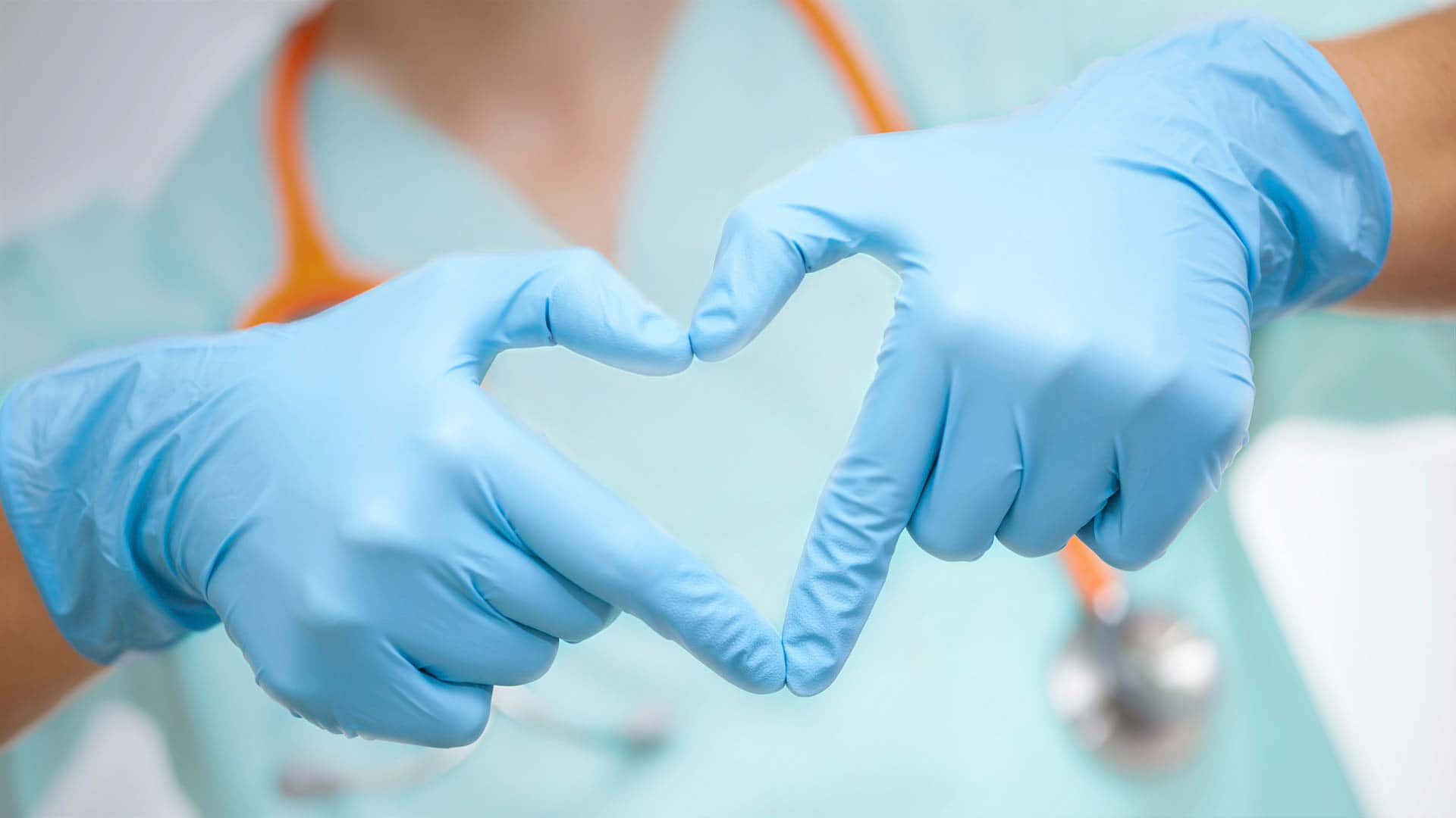 A Nurse In Blue Gloves Making A Heart Shape