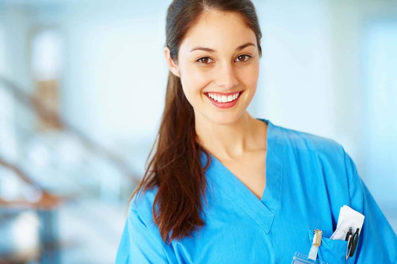 A Smiling Nurse In Blue Scrubs