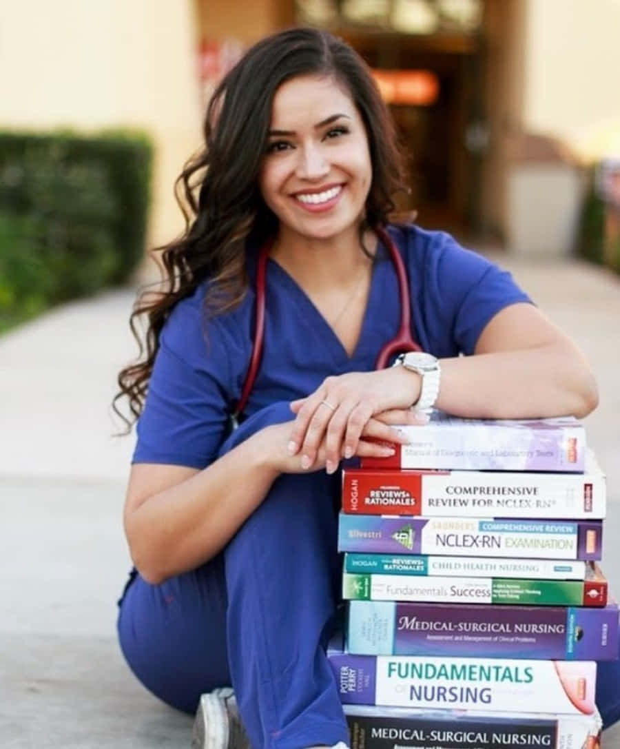 A Young Woman In Scrubs Sitting On A Stack Of Books
