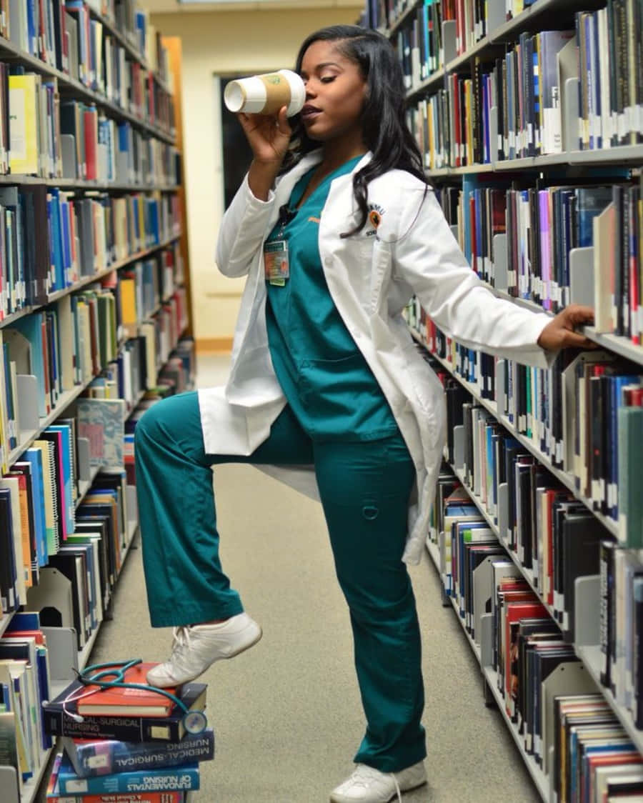 A Woman In A Lab Coat Drinking Coffee In A Library