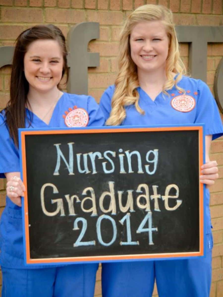 Duasenfermeiras Segurando Um Cartaz Que Diz Formada Em Enfermagem 2014