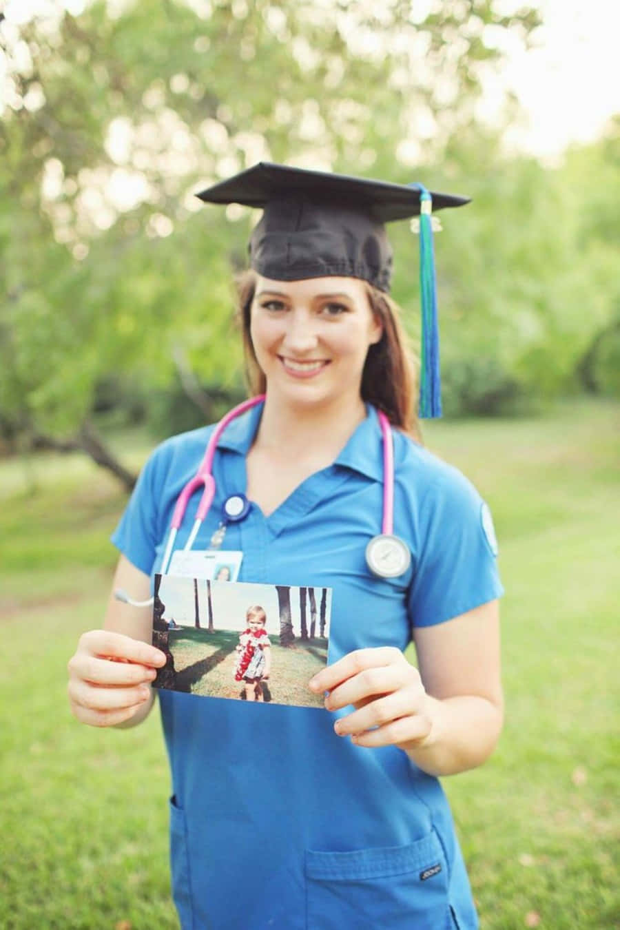 A Young Woman In A Blue Scrubs Holding A Photo