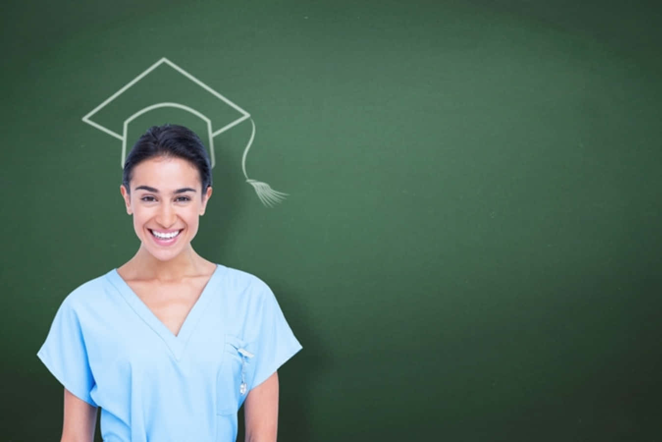 A Woman In Scrubs Standing In Front Of A Blackboard With A Graduation Cap
