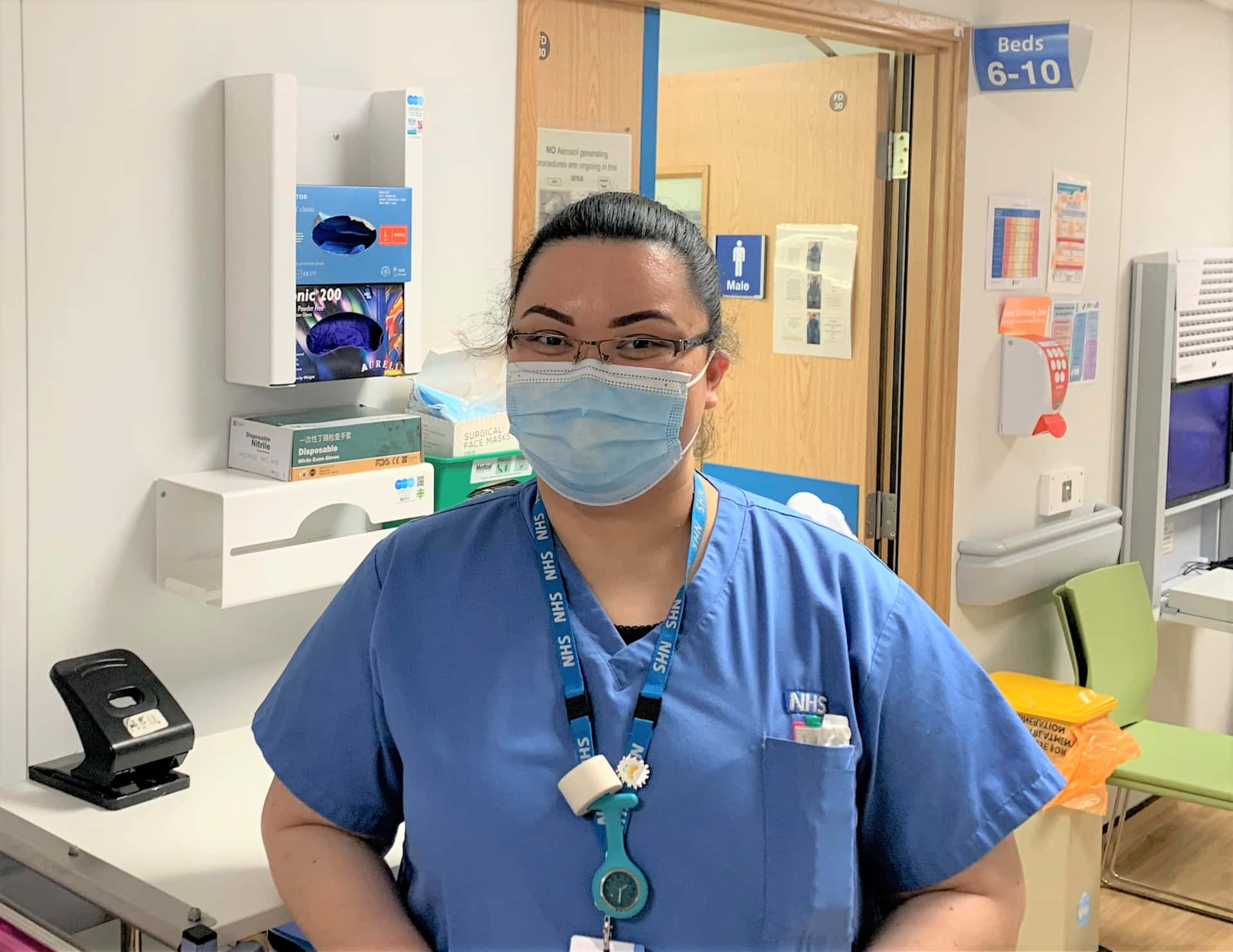 Einekrankenschwester Trägt Eine Maske Und Steht In Einem Krankenzimmer.