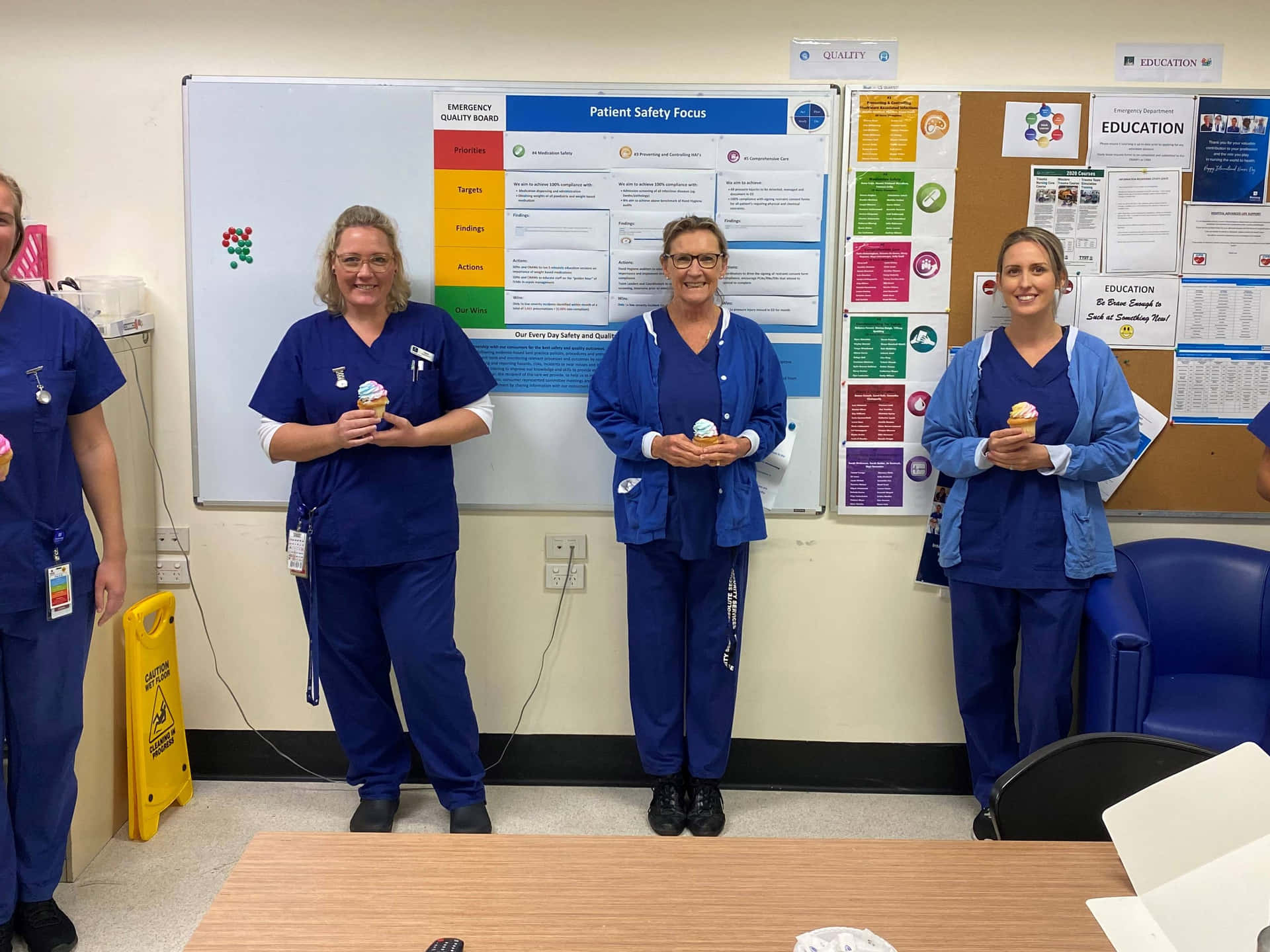 A Group Of Nurses Standing In Front Of A Bulletin Board