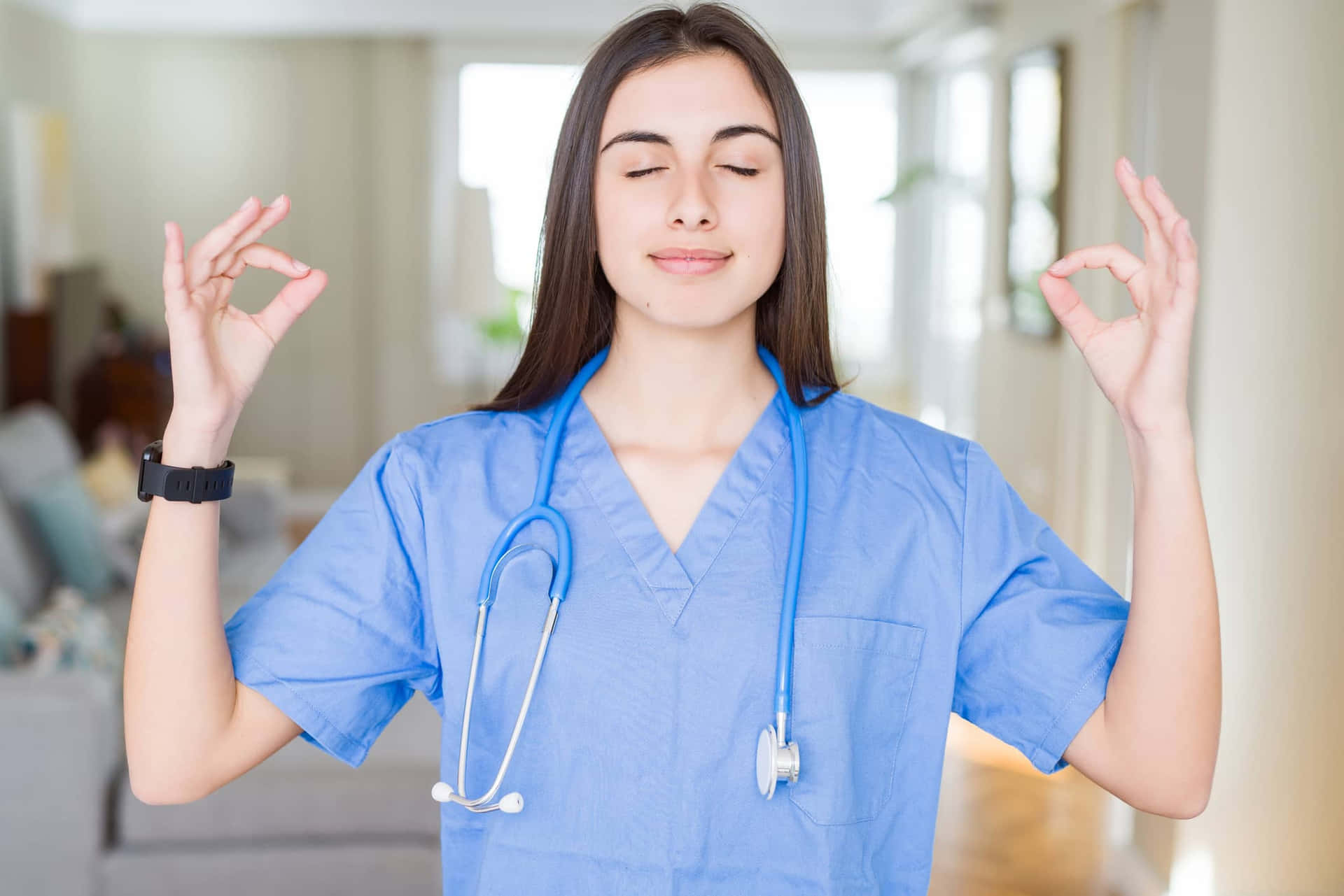 A Nurse In A Blue Scrubs Making A Yin Yang Sign