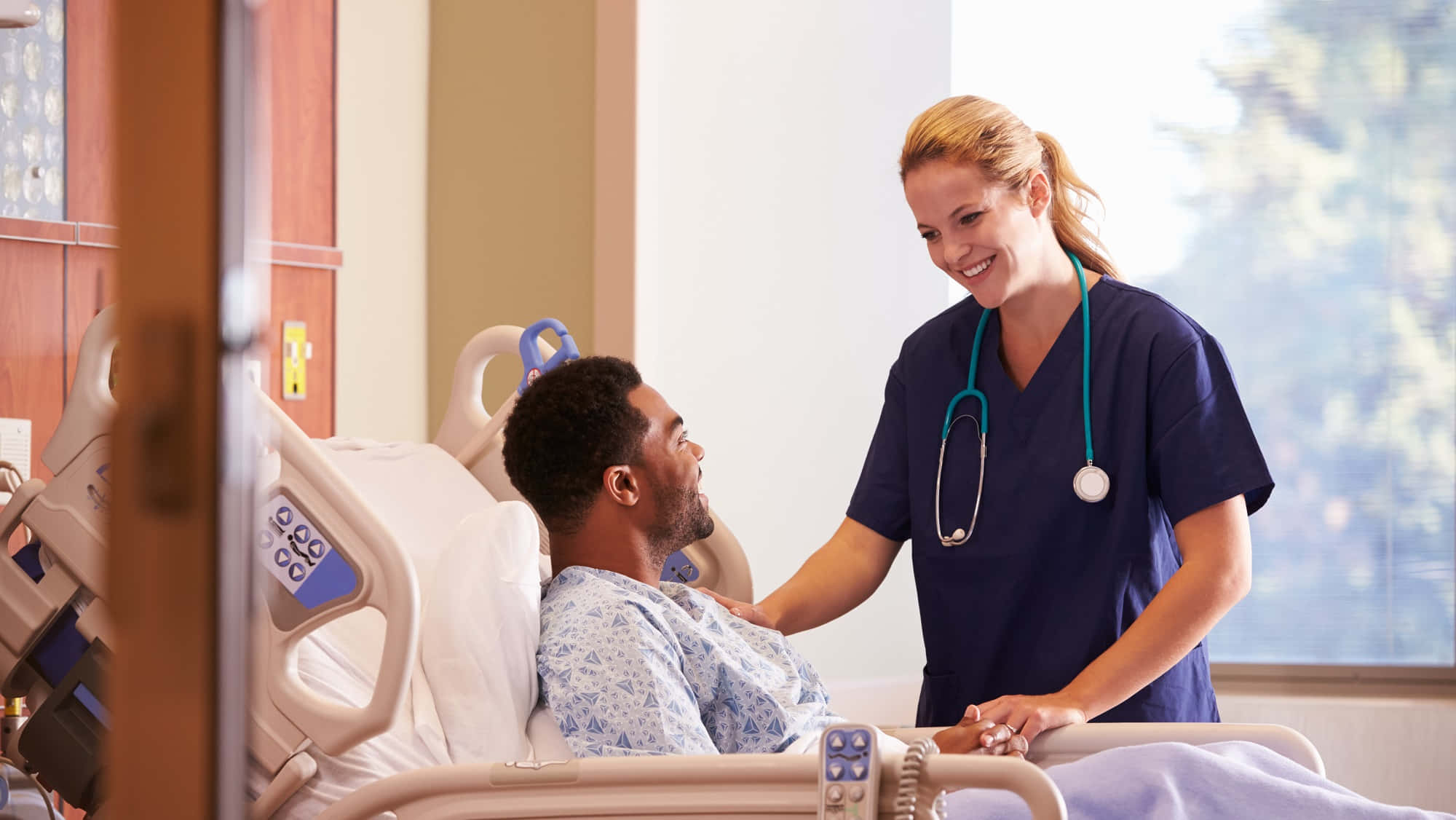 Unaenfermera Está Hablando Con Un Paciente En Una Cama De Hospital.