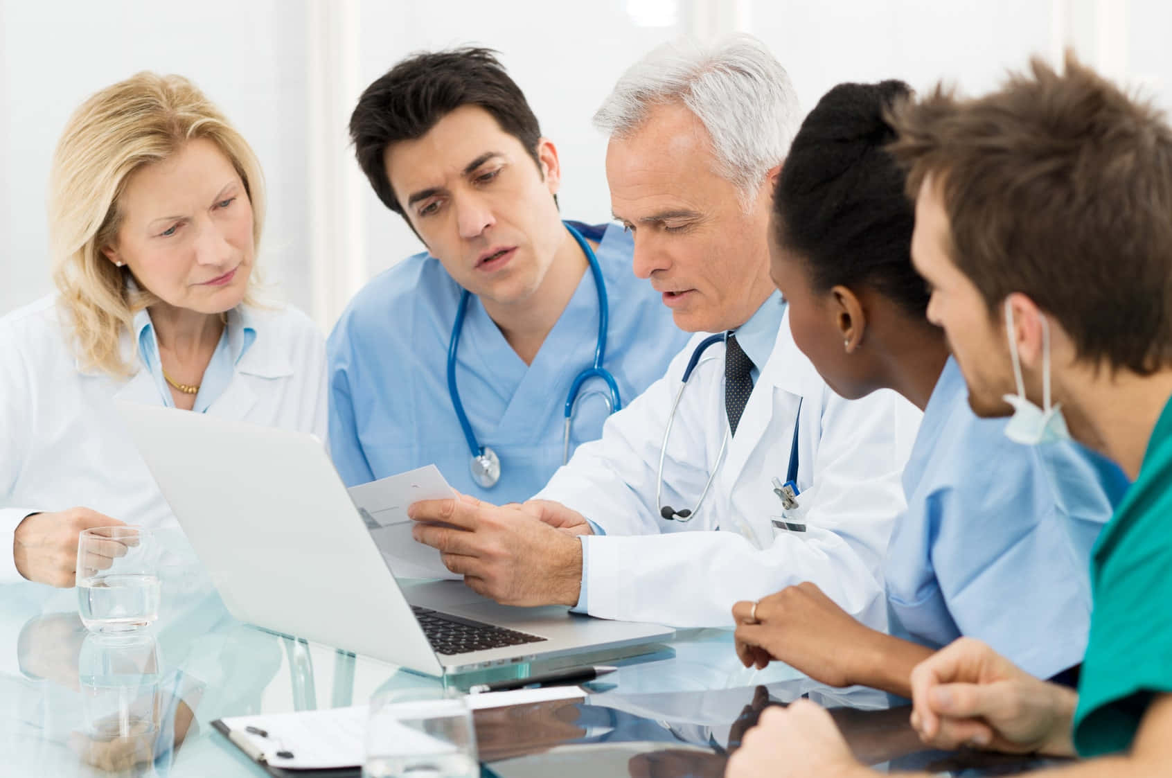 A Group Of Doctors Looking At A Laptop