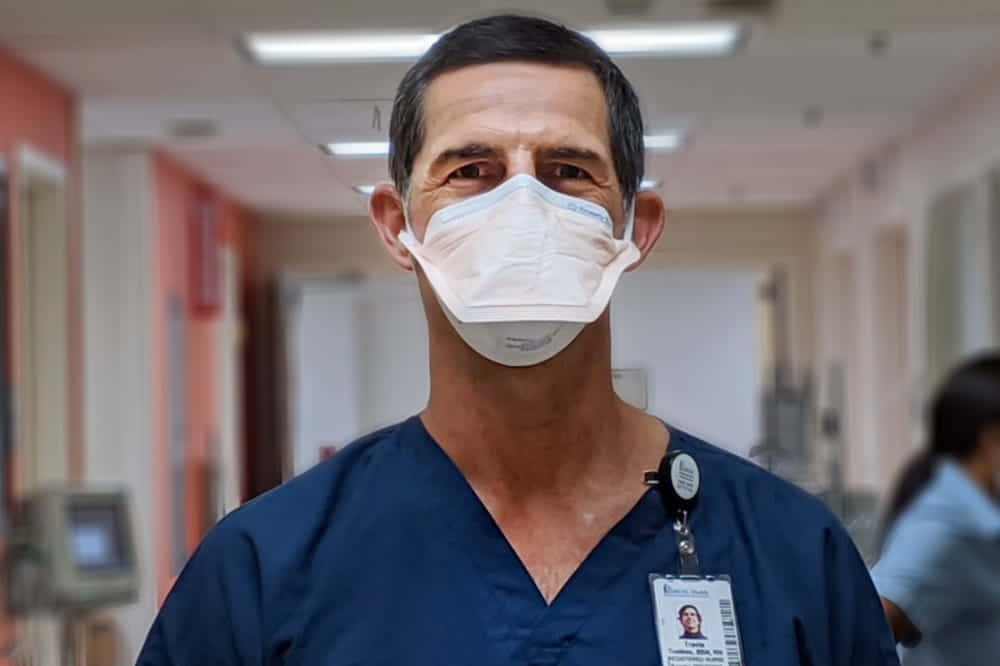 Einmann Trägt Eine Chirurgische Maske In Einem Krankenhausflur.
