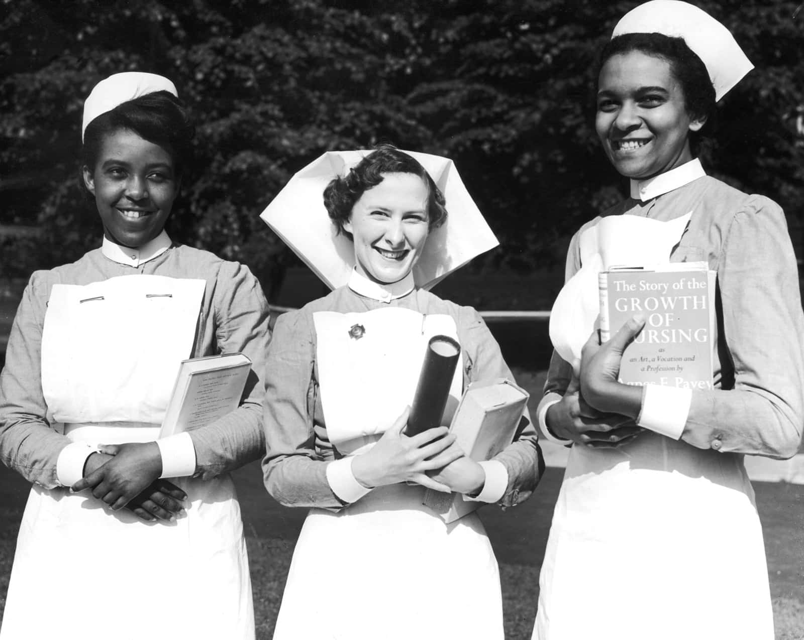 Three Nurses In Uniform Standing In Front Of A Building