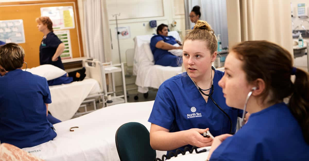 Ungrupo De Enfermeras Con Uniformes Azules En Una Habitación De Hospital.