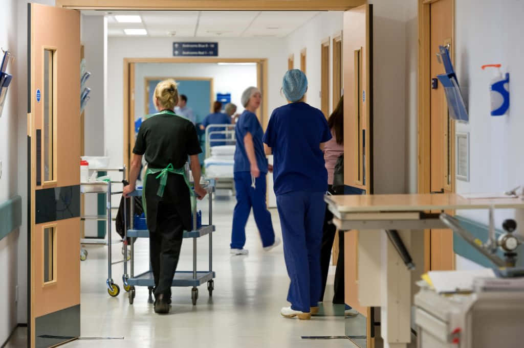 A Group Of Nurses Walking Down A Hallway