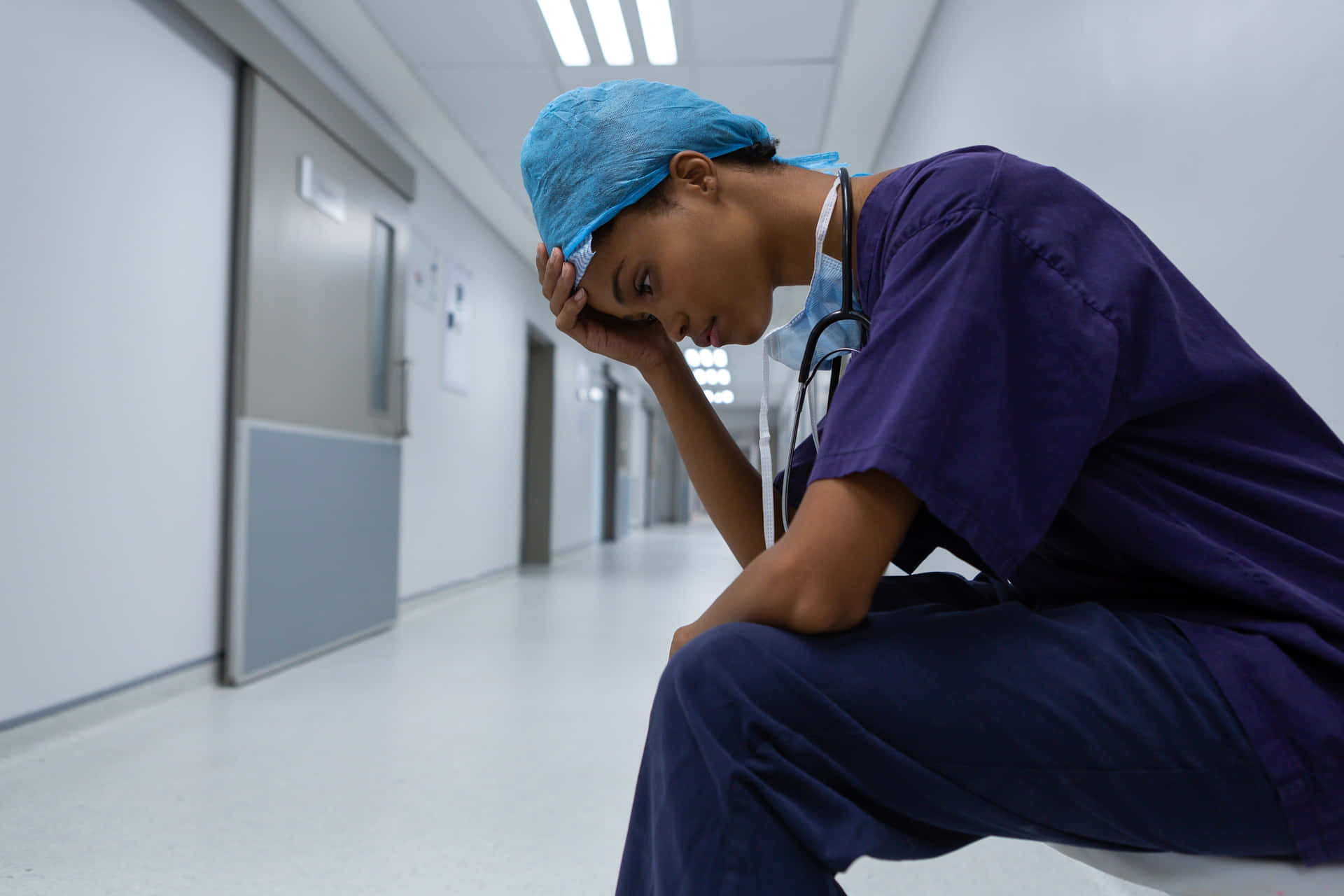Ensjuksköterska Som Sitter På En Toalett I En Sjukhuskorridor