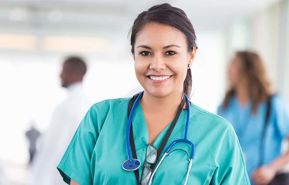 A Female Nurse Is Smiling In A Hospital Hallway