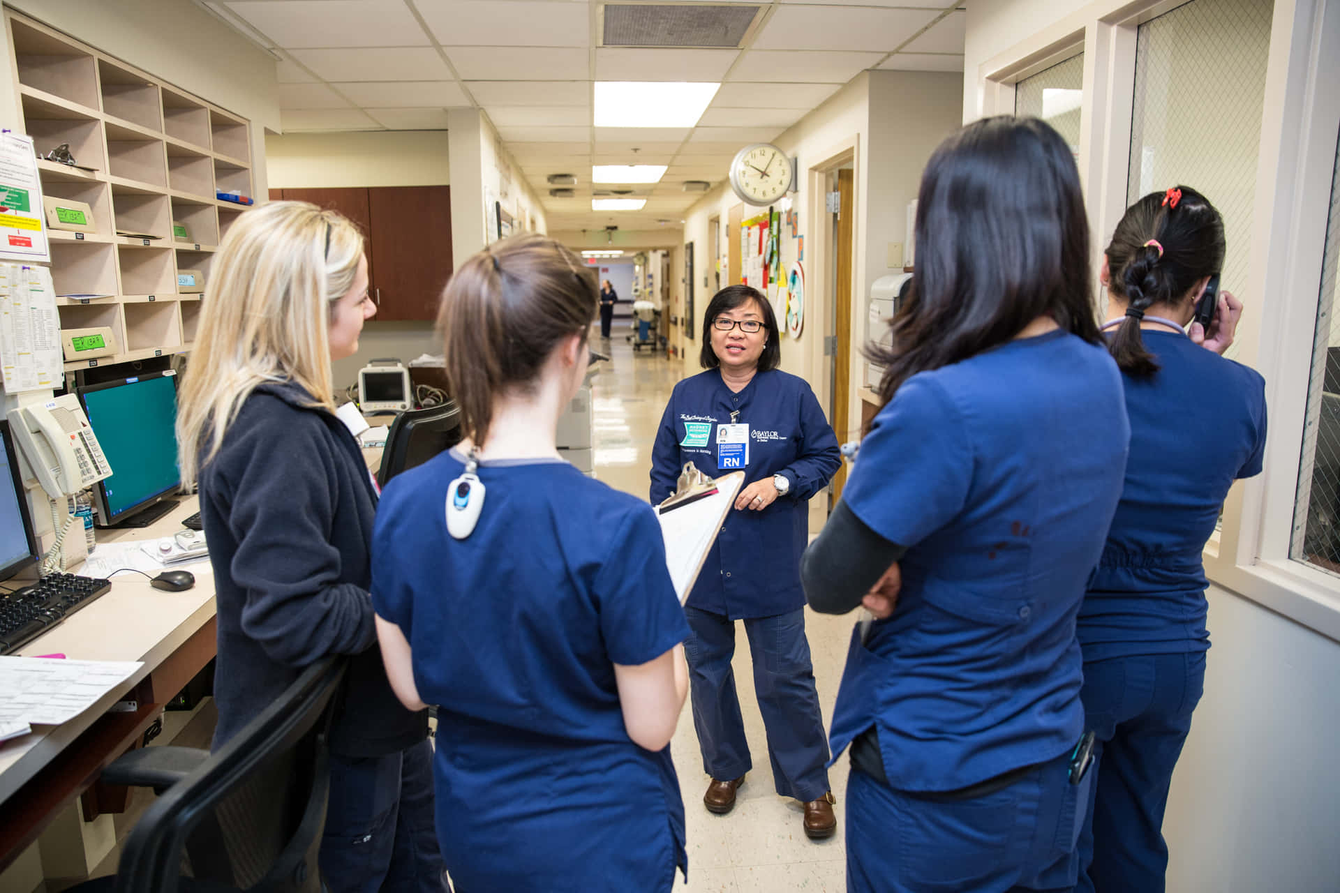 A Group Of Nurses Talking In A Hallway