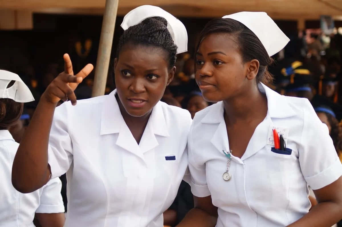 Two Nurses Standing Next To Each Other