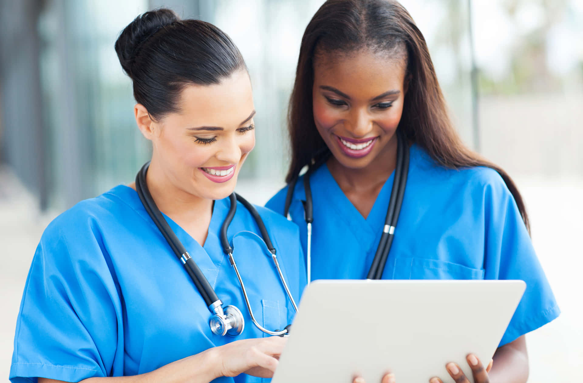 Two Nurses Are Looking At A Laptop