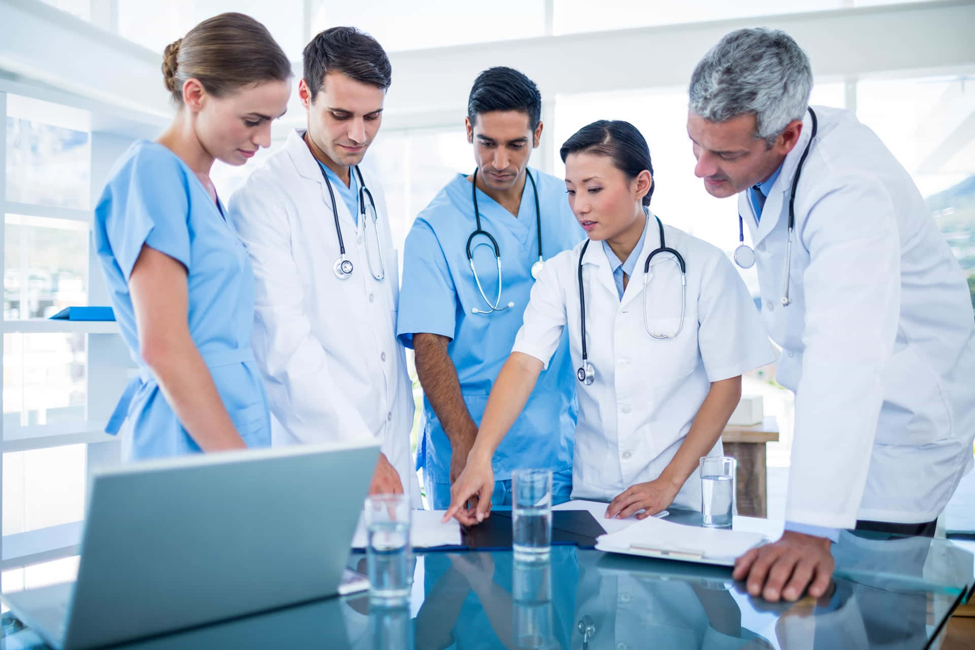 A Group Of Doctors Looking At A Laptop