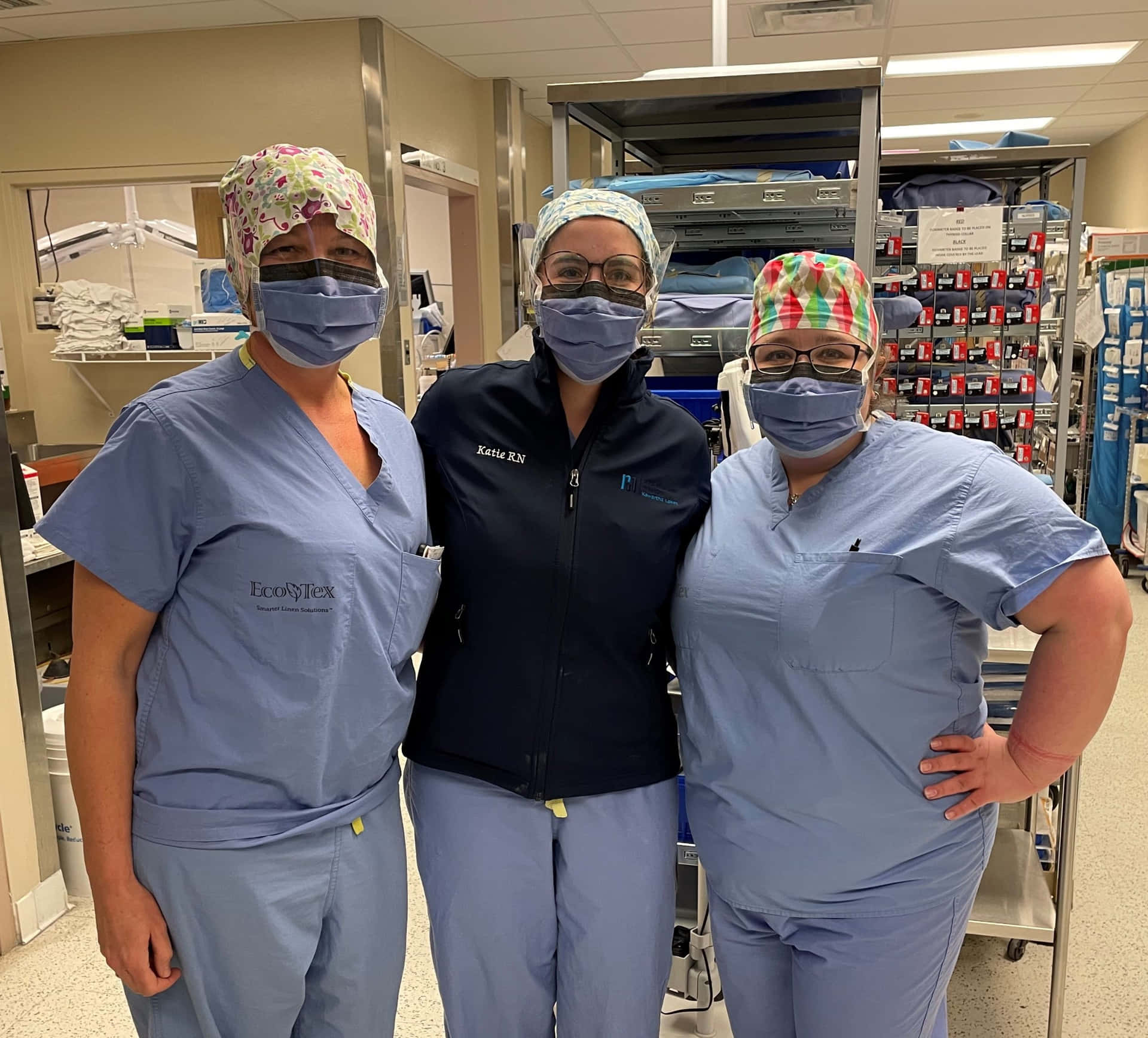 Three Women In Scrubs Standing In A Hospital Room